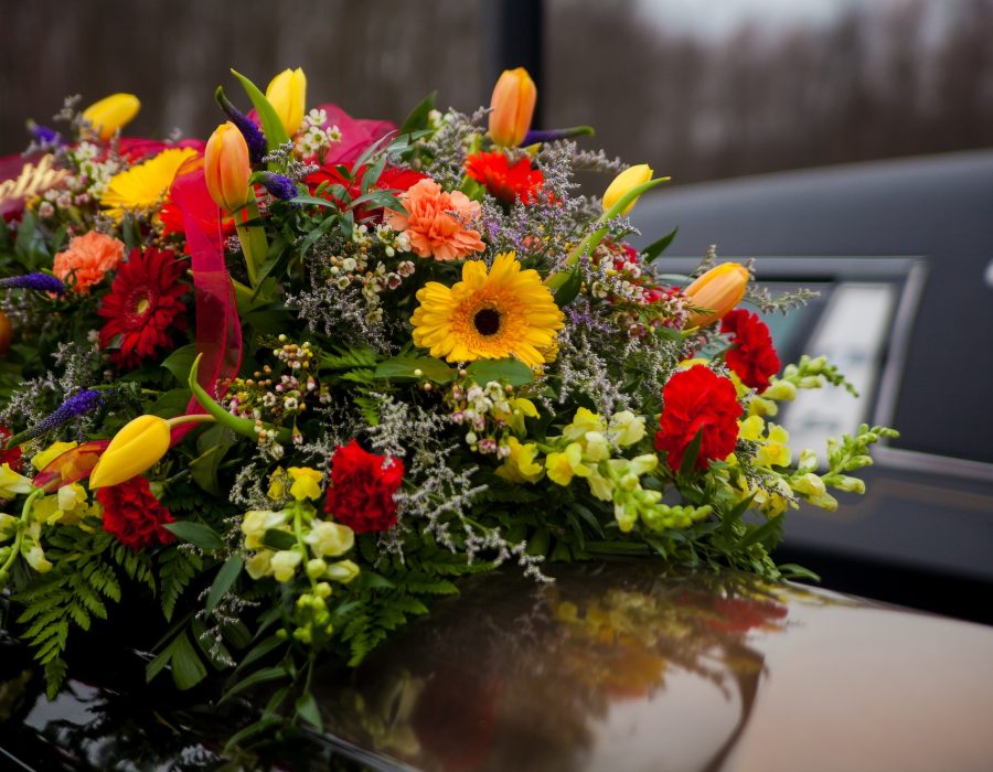Funeral Casket and flowers next to hearse